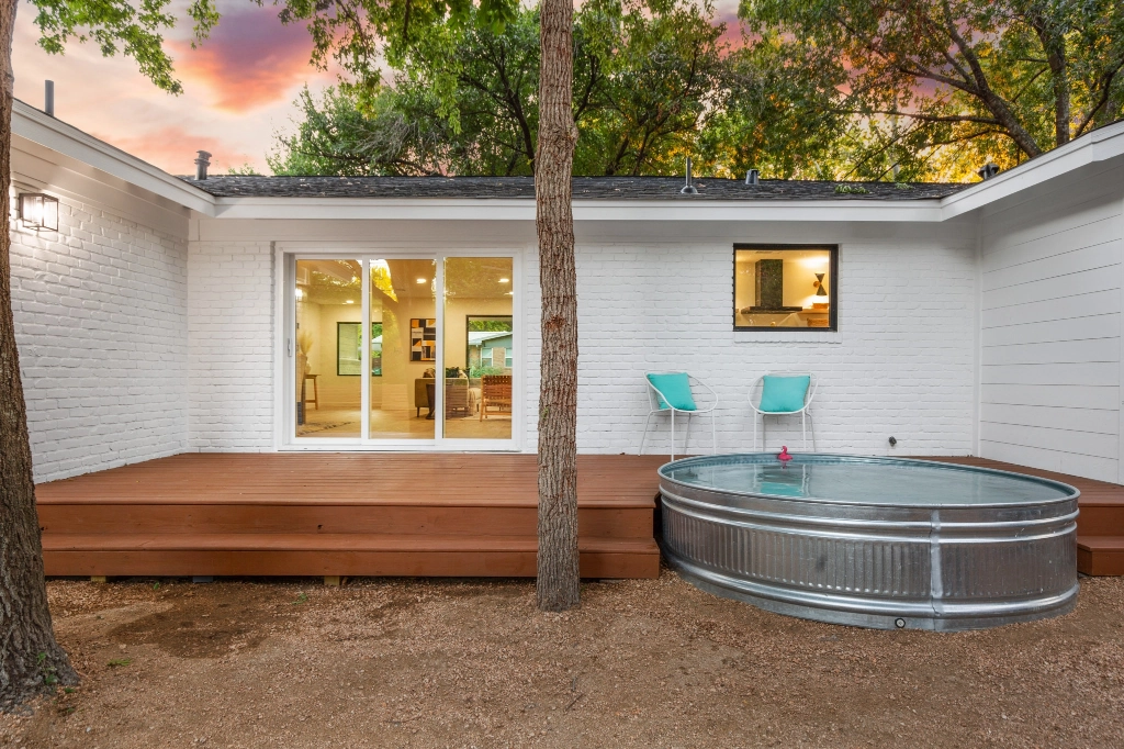 Home exterior view of backyard deck and pool.